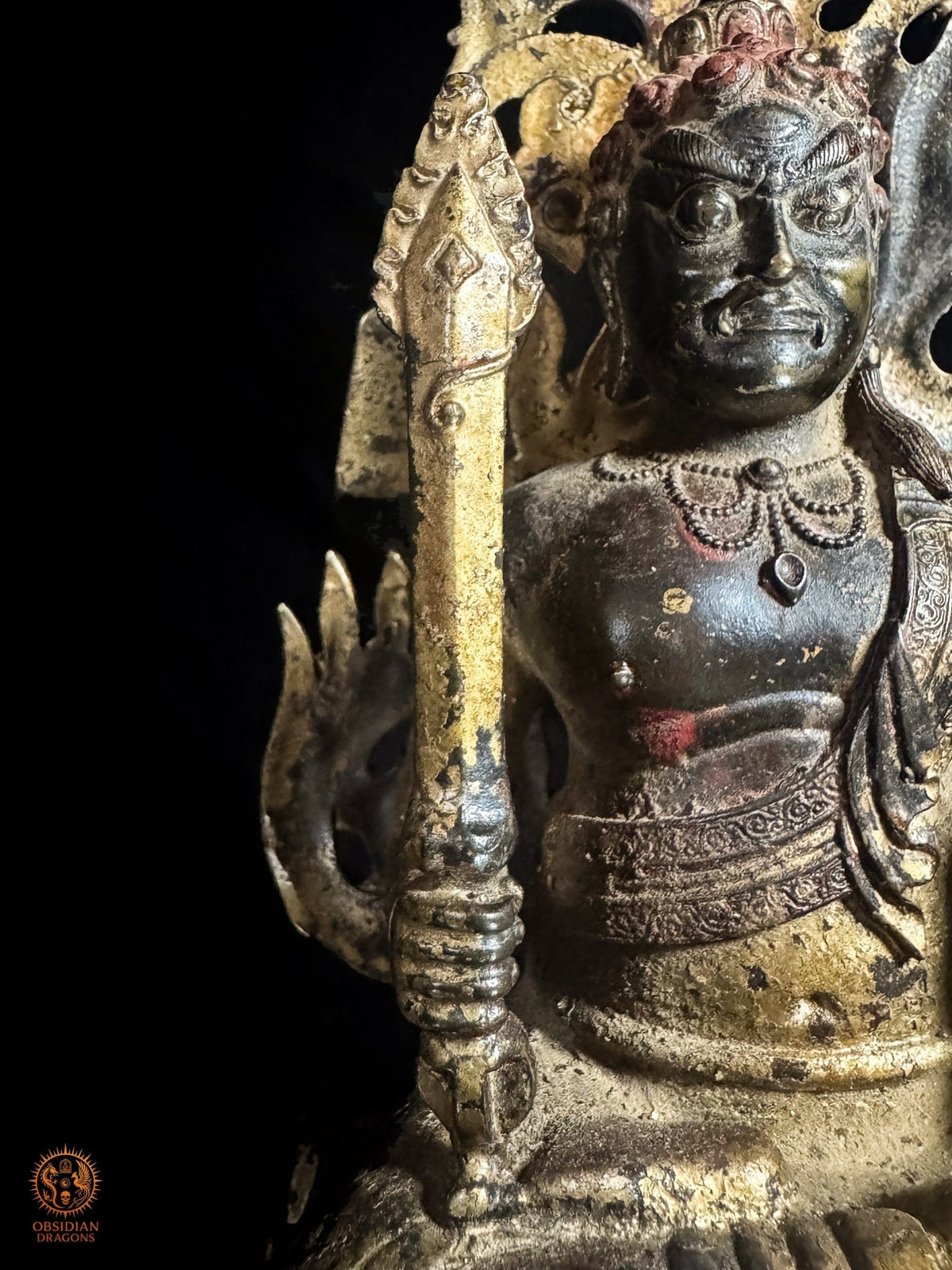 Détail de l’épée de sagesse tenue par Fudō Myōō, avec poignée inspirée du vajra devant la mandorle de flammes en bronze.