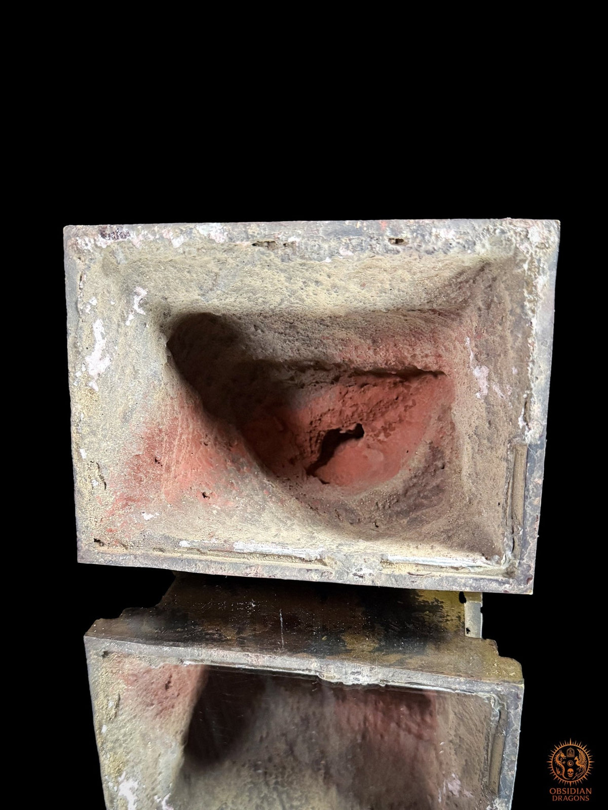 Vue du dessous creux de la statue d’Acala en bronze, révélant la cavité de fonte et les traces rouges du noyau réfractaire.