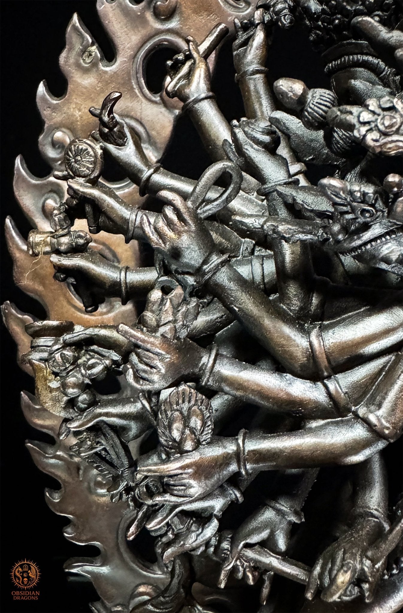 Gros plan sur les mains et objets rituels de Kalachakra aux 24 bras, statue tantrique tibétaine en bronze riche en cuivre
