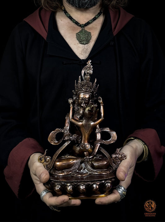 Statuette de Vajrasattva en yab yum en bronze, haute de 28 cm, présentée entre deux mains pour apprécier son échelle - Obsidian Dragons