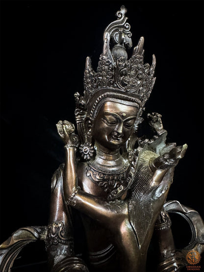 Détail du visage, de la haute couronne et des parures de Vajrasattva en bronze, avec sa parèdre enlacée