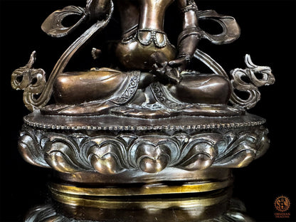 Gros plan sur le socle de lotus de Vajrasattva en bronze, les jambes croisées et les bordures décorées du vêtement.