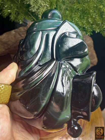 Dos de la statuette de Budai en obsidienne œil céleste tenue en main, montrant les plis sculptés du vêtement et les reflets argentés - Obsidian Dragons