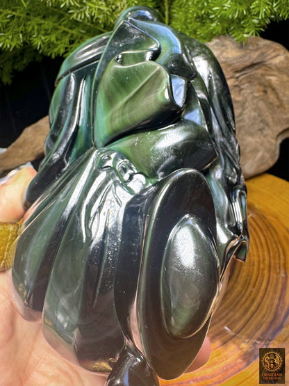Budai en obsidienne œil céleste vu de dos et de trois quarts, tenu en main, avec des drapés sculptés aux reflets verts et argentés.