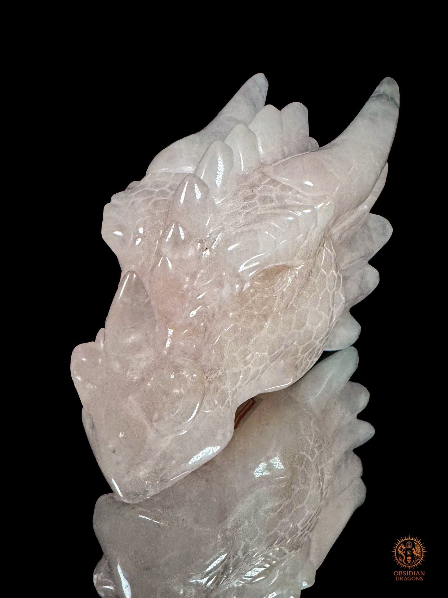 Tête de dragon sculptée artisanalement en quartz rose du Brésil, orientée vers la gauche avec détails des écailles, de l’œil et des cornes